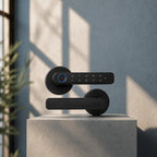 A modern black smart door lock with a touch keypad and blue accent ring, mounted on a matching black handle, displayed on a concrete pedestal against a textured wall with soft window shadows.