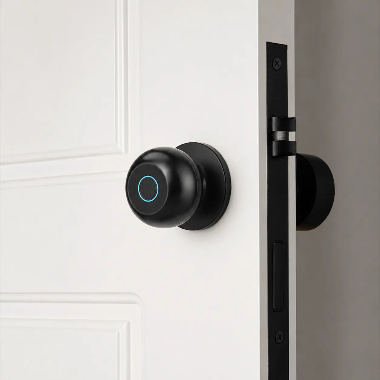 A matte black smart door lock with a circular touch panel and glowing blue ring, mounted on a white paneled door next to a black latch.