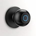 A modern matte black smart doorbell with a circular blue LED light ring, mounted on a matching round black wall plate against a clean white background.