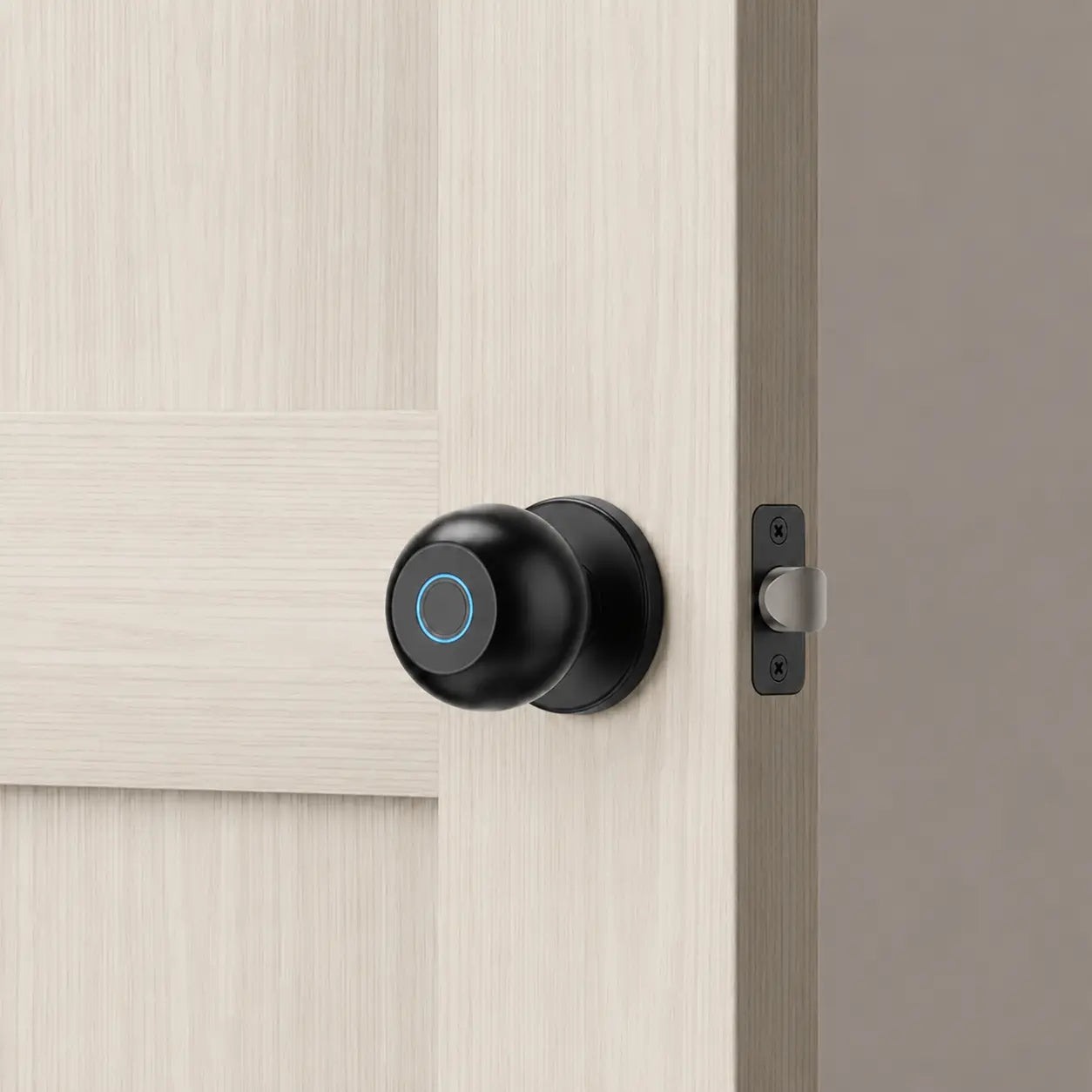 A modern black smart doorbell with a blue ring indicator light mounted on a light wood paneled door next to a metal latch.