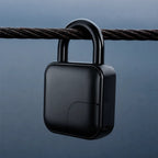 A matte black smart padlock with a square body and a thick shackle, hanging from a dark metal cable against a dark blue-gray gradient background.